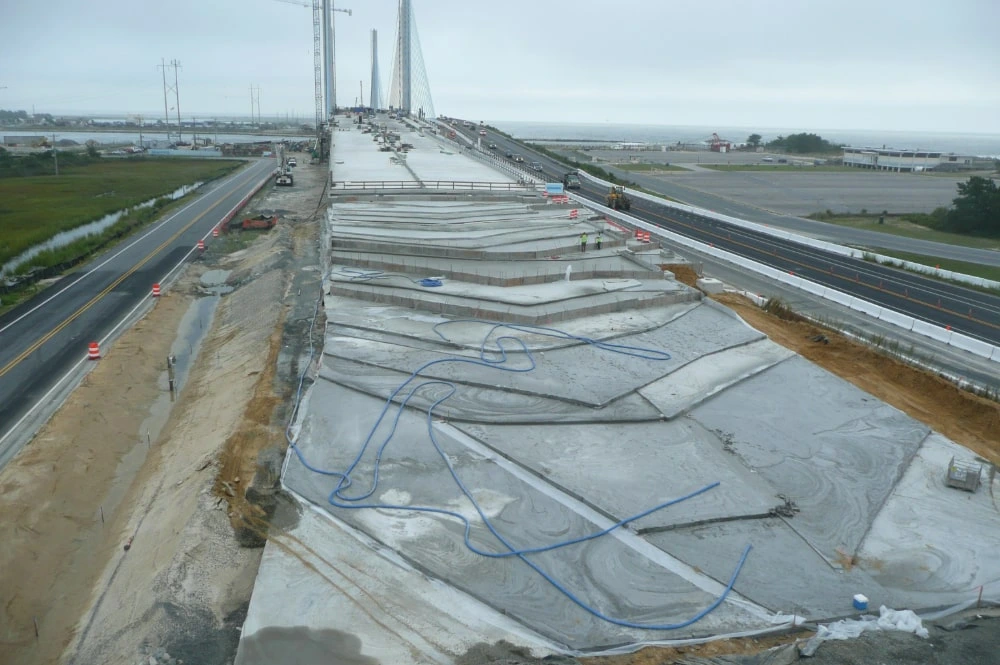 Elastizell Systems workers applying lightweight cellular concrete as load-reducing fill for construction site stabilization